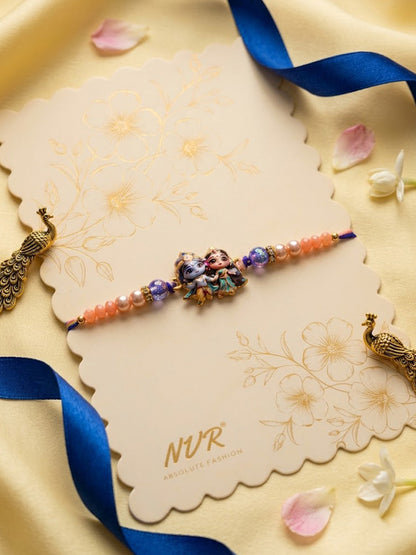 NVR Radha Krishna Multicolor Artificial Beads Thread Rakhi With Roli Chawal Chandan Mishri