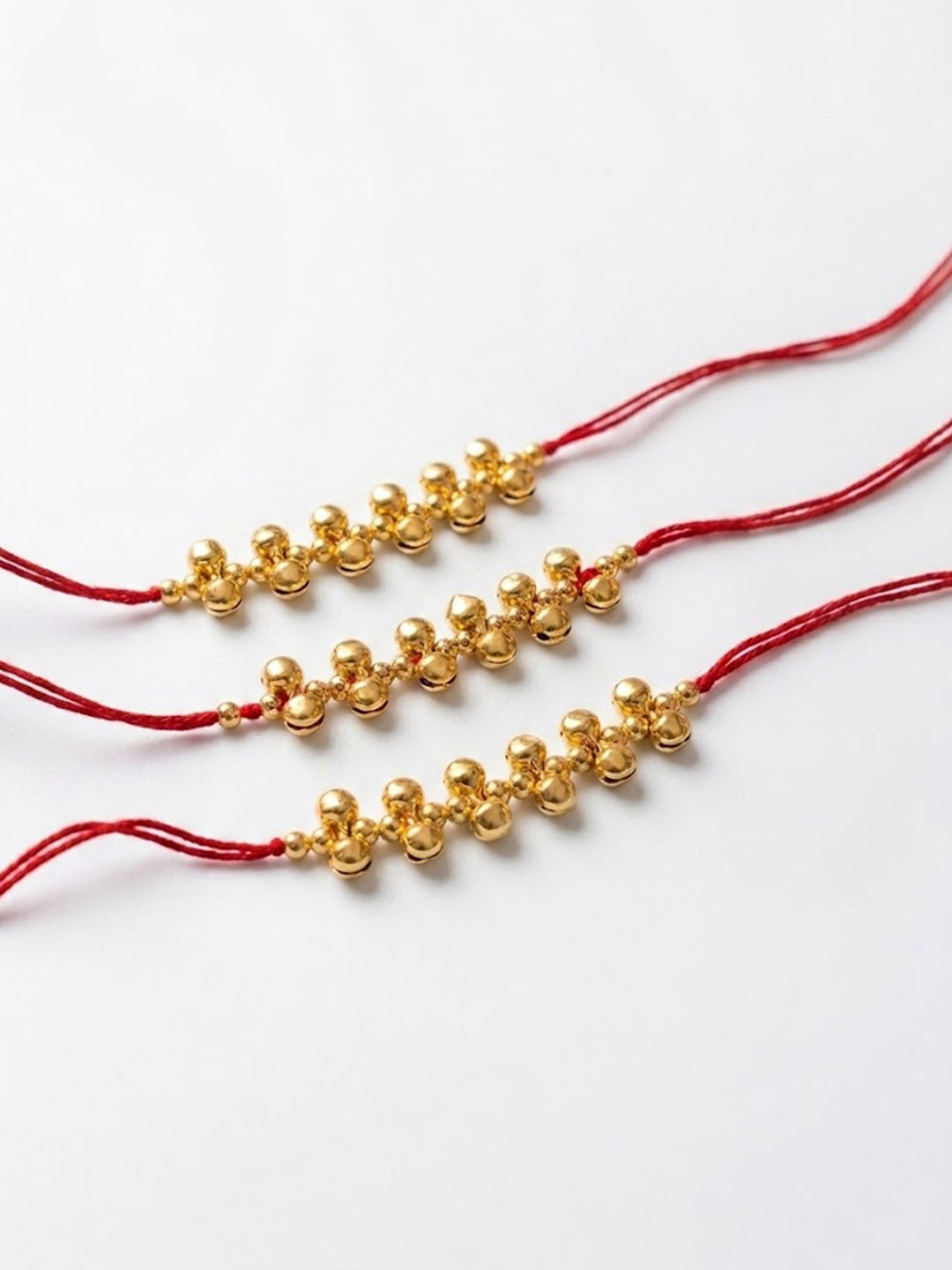 NVR Set of 3 Gold Toned Ghungroo & Red Thread Rakhi With Roli Chawal Chandan Mishri